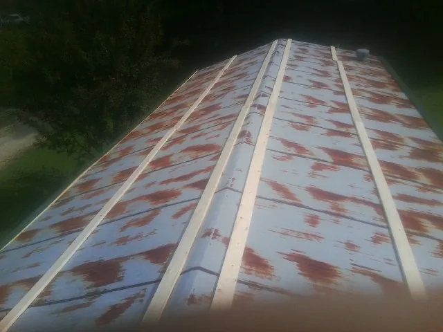 Rusted metal roof panels with new wood purlins before replacement — Storm Damage Roof Repair in Shorewood by Roofing Brothers