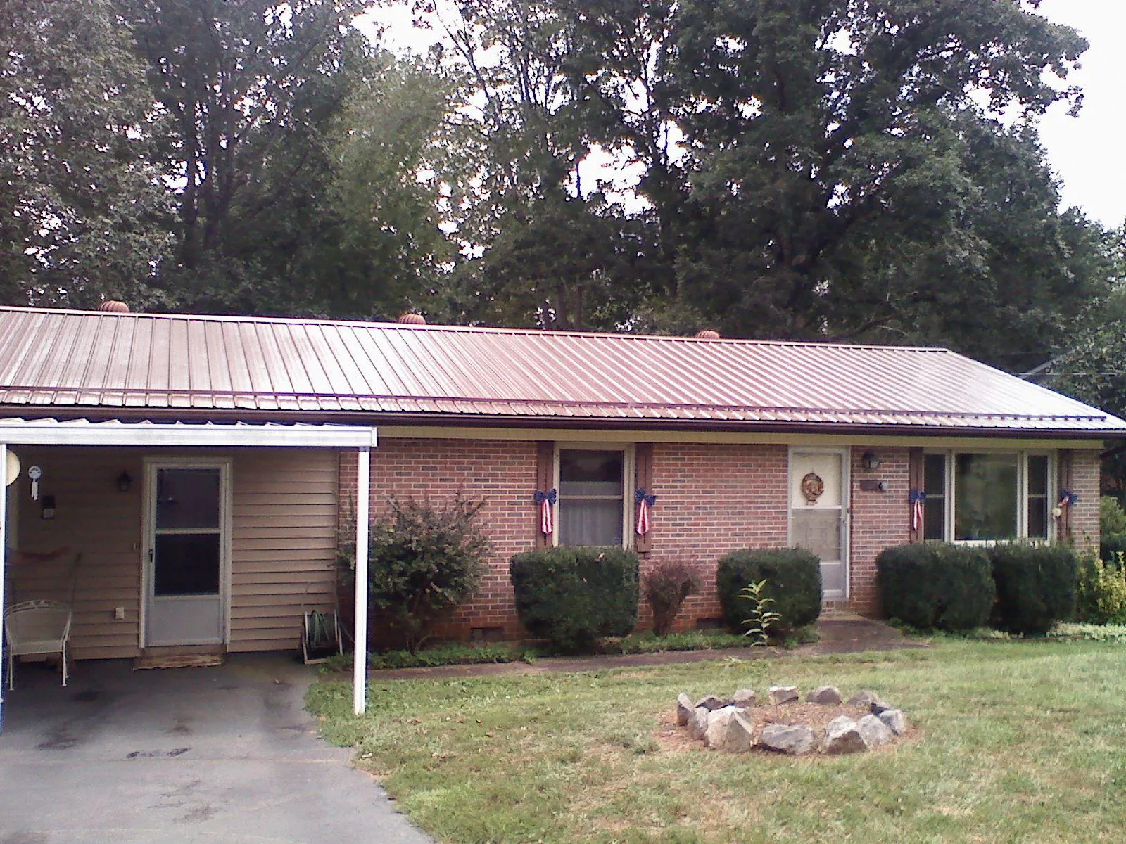 Bronze metal roof and carport on a brick ranch home — Roof Repair work by our crew in Shorewood
